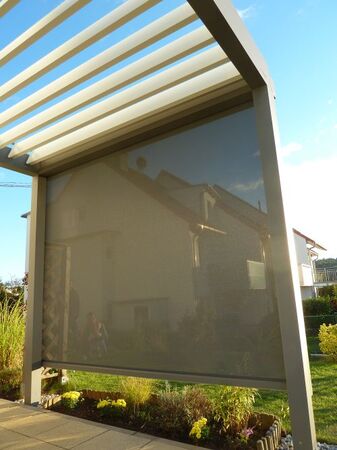 Senkrechtmarkise als Sonnenschutz an moderner Terrassenüberdachung mit Gartenansicht.