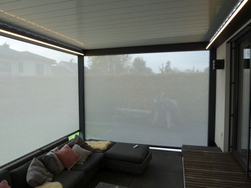 Überdachte Terrasse mit modernen Sichtschutz-Rollläden und gemütlicher Lounge-Ecke.